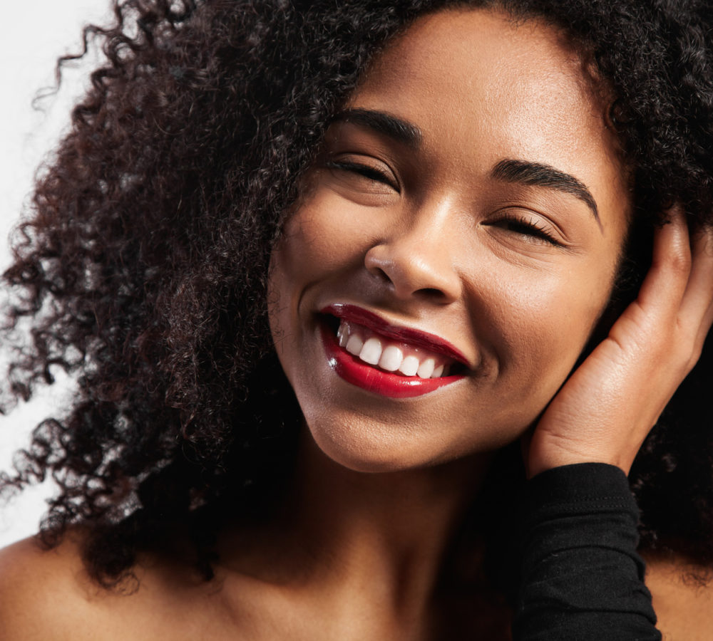 happy smiling black woman with afro curly hair
